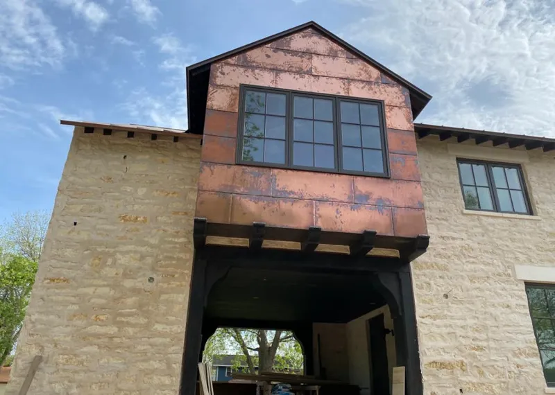 Copper metal panel facade on a stone building for Roof Repair in Kill Devil Hills